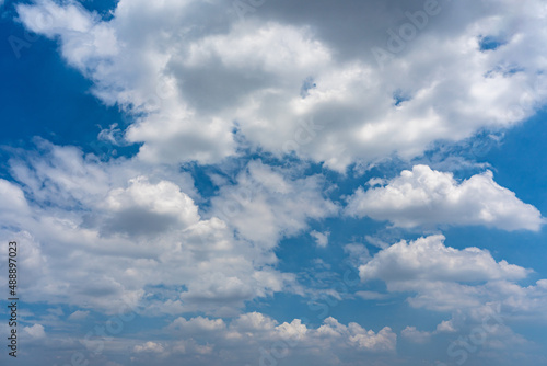 White cumulus clouds on the blue sky background