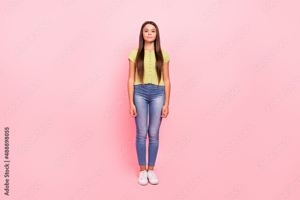Photo of positive cute cheerful little lady posing wear green top jeans footwear isolated pink color background Photo of positive cute cheerful little lady posing wear green top jeans footwear isolated pink color background