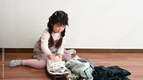 Girl helping to fold family laundry