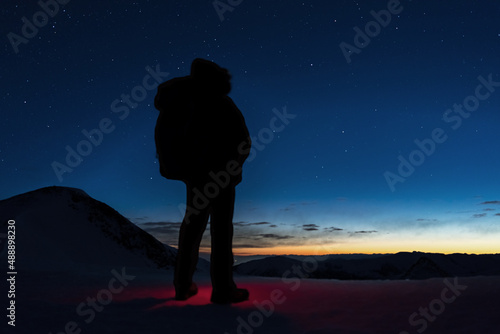 silhouette of a person standing on the top of the mountain