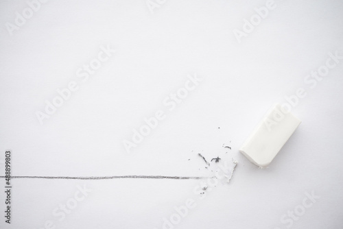 Flat lay of white eraser delete black line pencil on white paper background copy space. Repair, remove, creative idea, imagination and education concept.