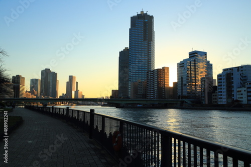 静かな隅田川テラスと高層ビル群の夕景