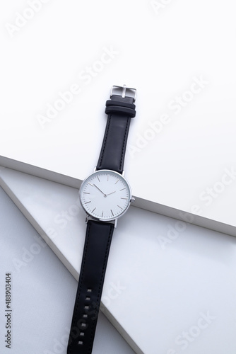 Men's watch with leather strap and white dial, isolated on a white background