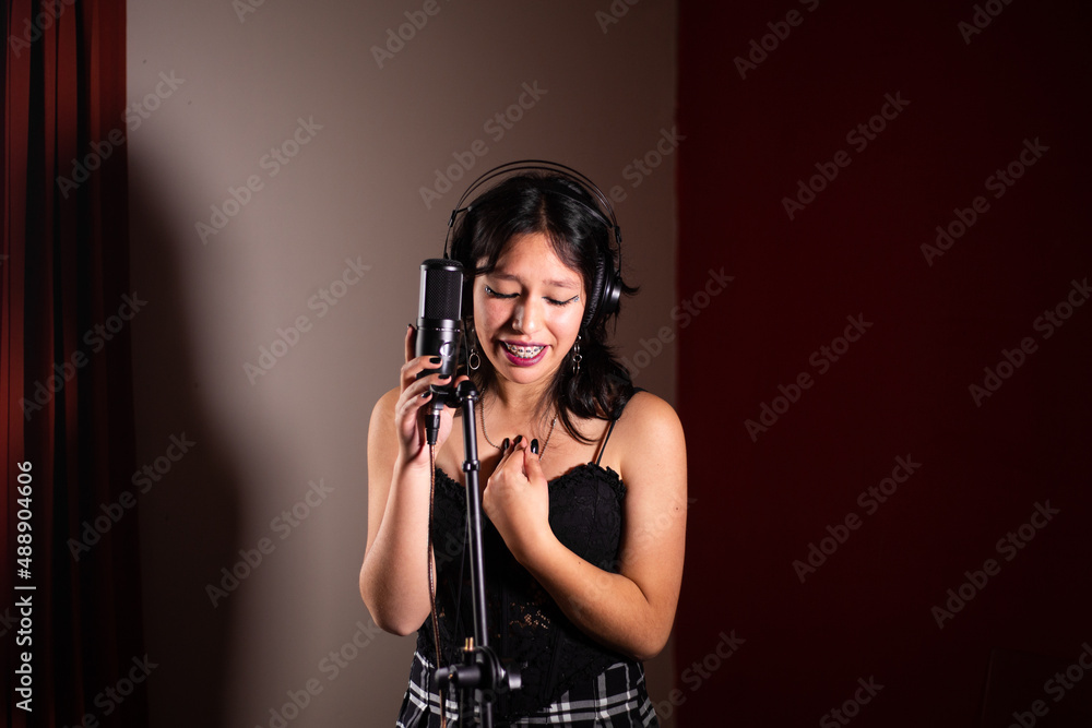 Mujer joven cantando emocionada en un estudio Mujer joven cantando emocionada en un estudio
