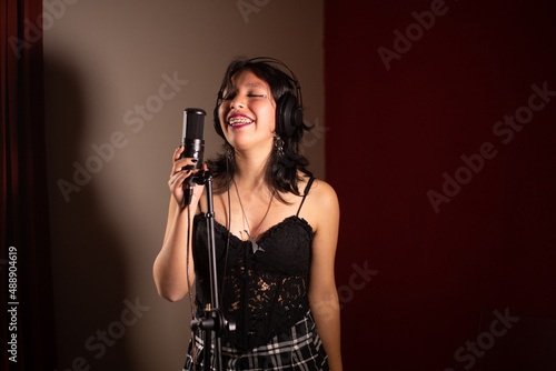Wallpaper Mural Mujer joven cantando emocionada en un estudio Torontodigital.ca