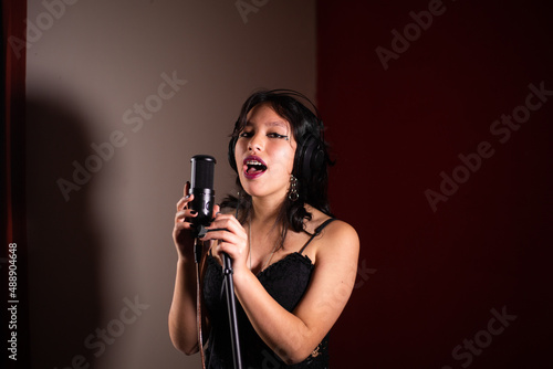 Wallpaper Mural Mujer joven cantando emocionada en un estudio Torontodigital.ca