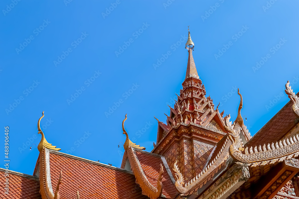 Fototapeta premium Thai style roof of Buddhist temple with blue sky.