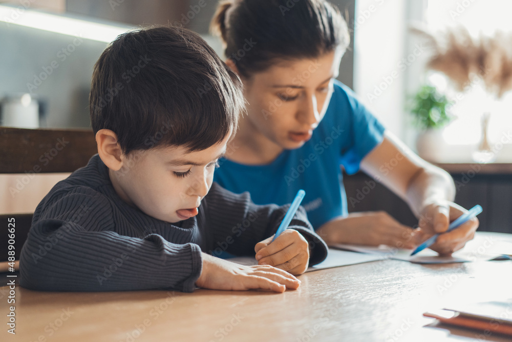 The mother spent the afternoon sitting in the kitchen with her son and checking the homework. Mom help boy learning, great design for any purposes. The mother spent the afternoon sitting in the kitchen with her son and checking the homework. Mom help boy learning, great design for any purposes.