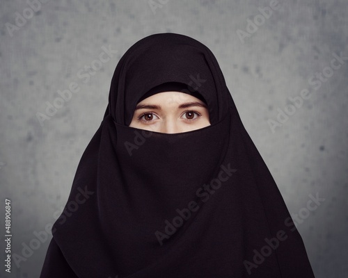 Tableau sur toile Portrait of young woman in black burqa with hidden face,
