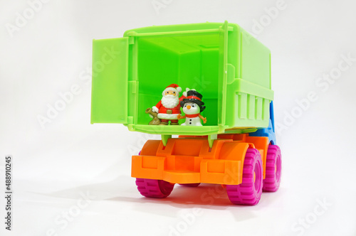 Toys Santa claus and snowman stand in the green back of a toy truck