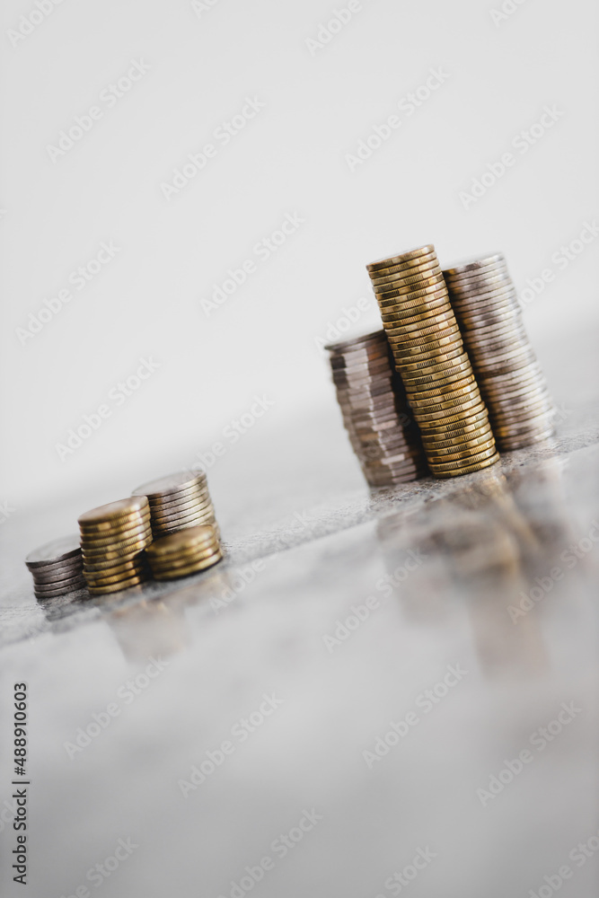 stacks of different coins divided between a small and a big group on ...