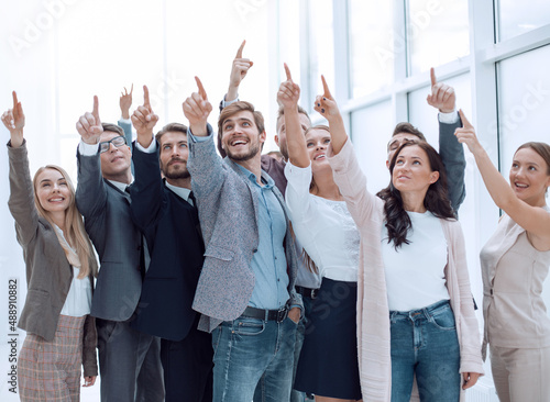 group of happy young business people pointing upwards