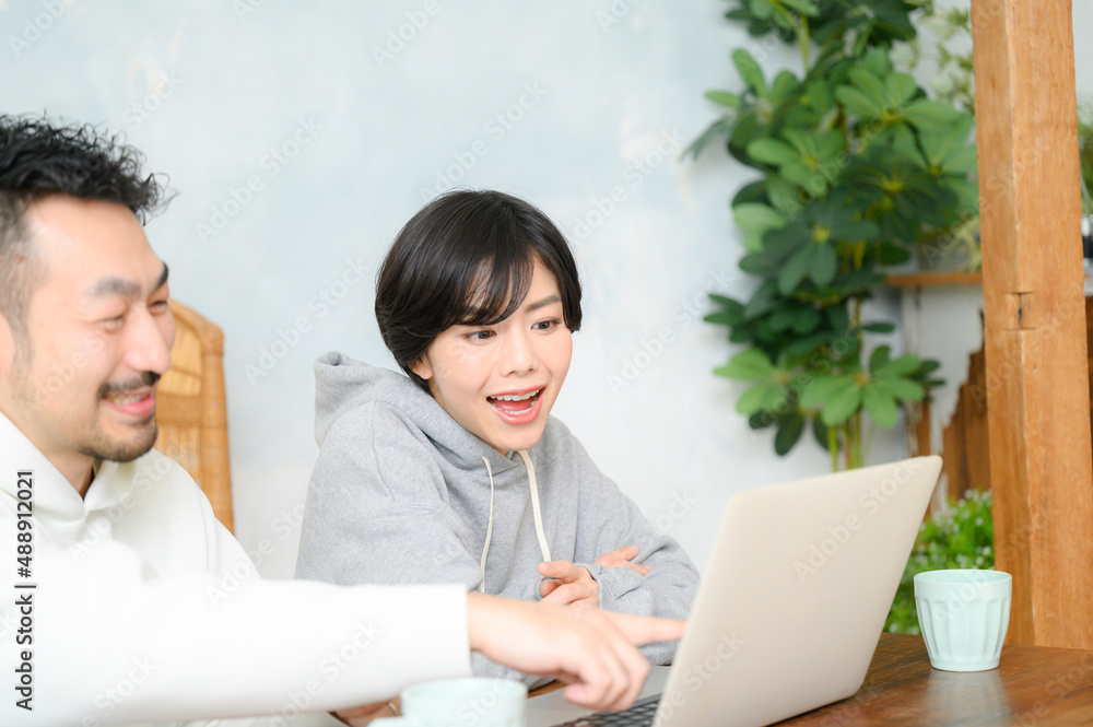 パソコンを見ながら指をさす若い夫婦 コピースペースあり パソコンを見ながら指をさす若い夫婦 コピースペースあり