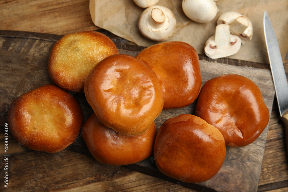 Delicious baked mushrooms pirozhki on wooden table Delicious baked mushrooms pirozhki on wooden table