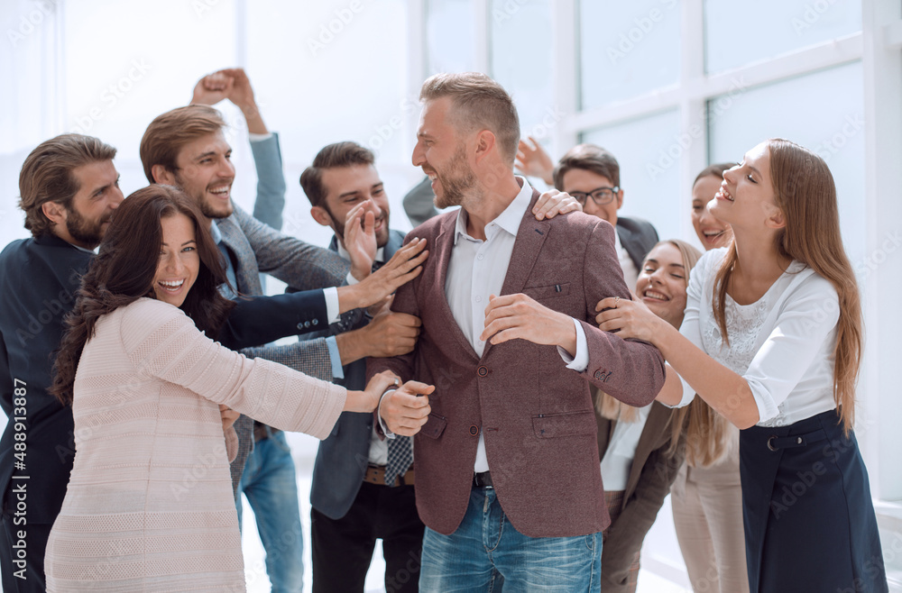 happy team of employees congratulating their colleague. happy team of employees congratulating their colleague.