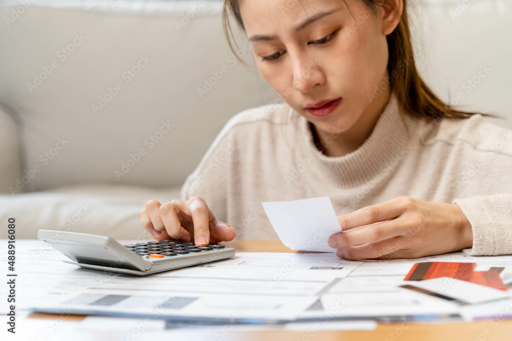 Financial owe asian young woman, girl sitting suffer, stressed and confused by calculate expense from invoice or bill, have no money to pay, mortgage or loan. Debt, bankruptcy or bankruptcy concept. Financial owe asian young woman, girl sitting suffer, stressed and confused by calculate expense from invoice or bill, have no money to pay, mortgage or loan. Debt, bankruptcy or bankruptcy concept.