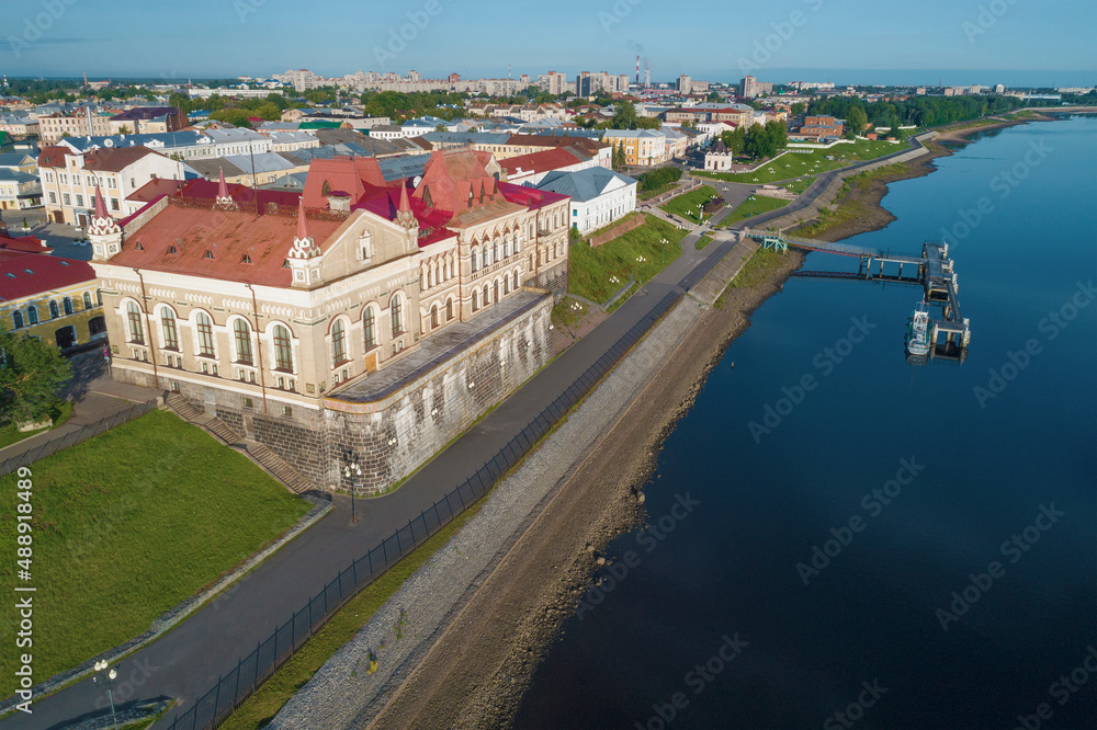 Obraz premium The old building of the Grain Exchange (1912) on the city embankment on a sunny July day. Shooting from a quadcopter. Rybinsk, Russia