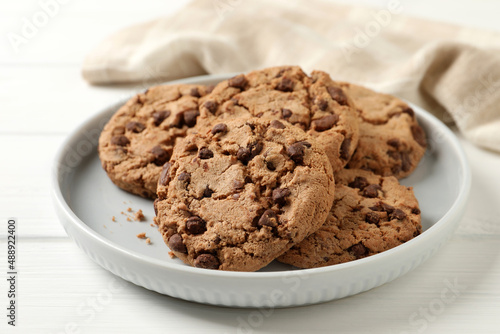 Delicious chocolate chip cookies on white wooden table, closeup