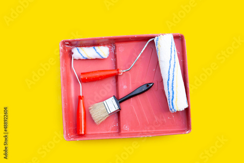 Paint rollers and brush in red paint tray