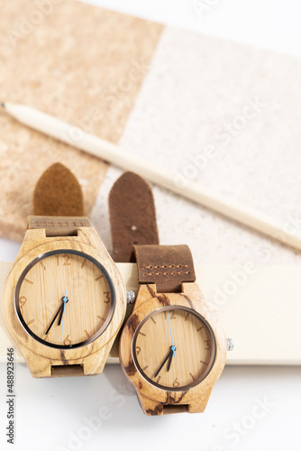 reloj de madera con cuaderno y lápices de colores