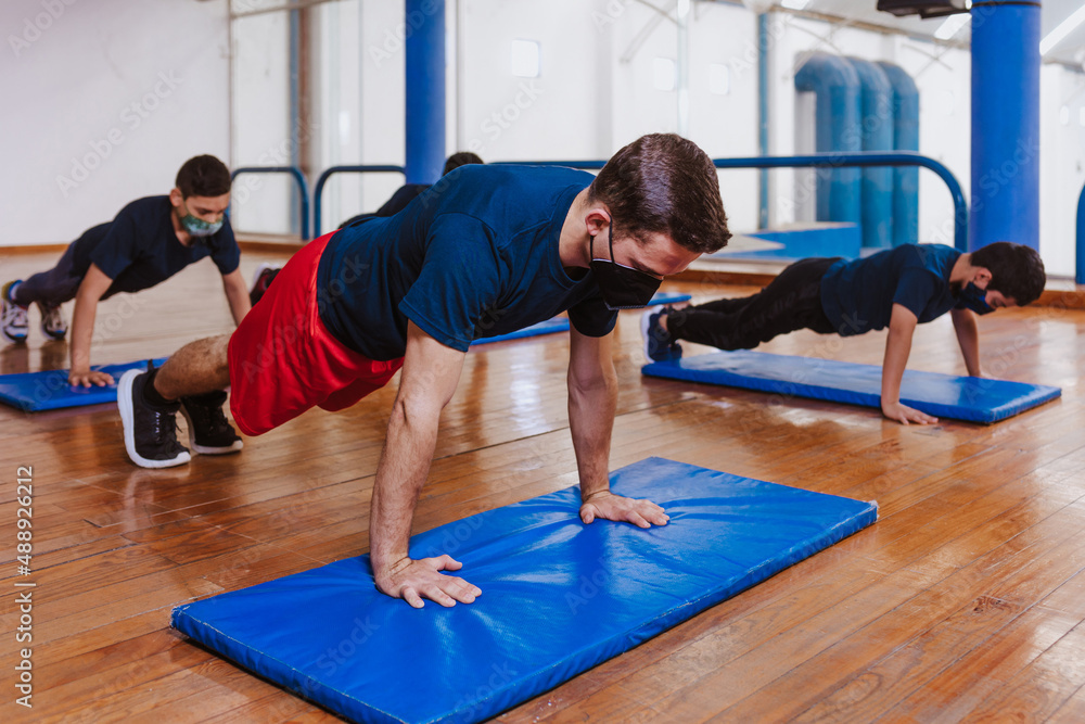 Latin teenagers doing exercise and planks work out with face mask for coronavirus pandemic covid Mexico Latin America Latin teenagers doing exercise and planks work out with face mask for coronavirus pandemic covid Mexico Latin America