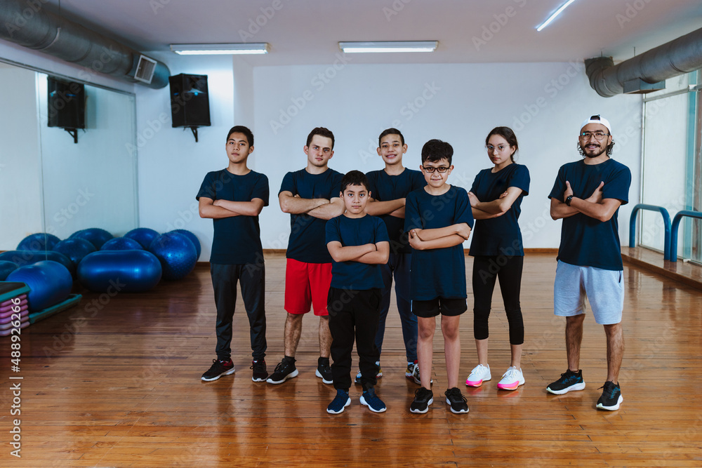 Latin teenagers and hispanic children with instructor man posing together in work out sport class in Mexico Latin America