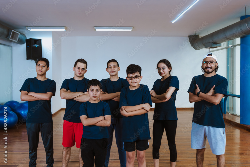 Fototapeta premium Latin teenagers and hispanic children with instructor man posing together in work out sport class in Mexico Latin America