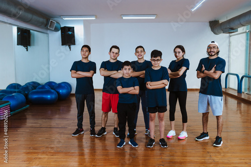 Latin teenagers and hispanic children with instructor man posing together in work out sport class in Mexico Latin America