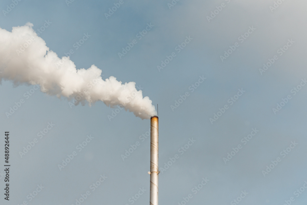 Pipe and smoke.Polluting air with white smoke from industrial chimney outdoors. CO2 emissions.Copy space. Pipe and smoke.Polluting air with white smoke from industrial chimney outdoors. CO2 emissions.Copy space.