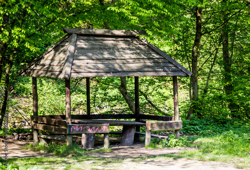 a rough wooden gazebo in the forest