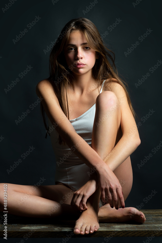 Young model girl with slim body. Portrait of elegant woman with light on a black background. Beautiful female face in the darkness. Young model girl with slim body. Portrait of elegant woman with light on a black background. Beautiful female face in the darkness.