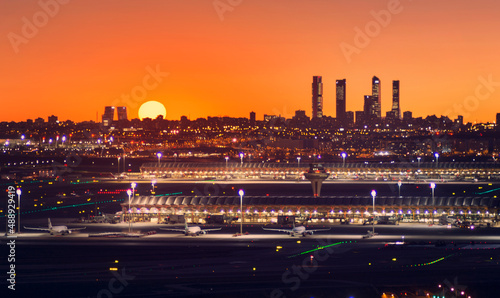 skiline de Madrid con el sol encima de torres kio y el aeropuerto