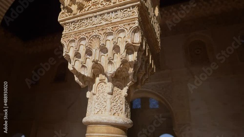 Alhambra palace in Granada, Andalusia, interior detail of marble pillar carving in moorish castle of Alhambra in Spain, famous tourist destination  photo
