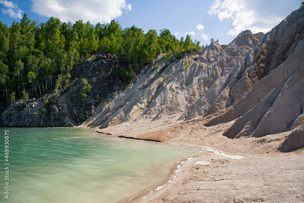 beautiful blue wild lake in the mountains with green forest	and beach