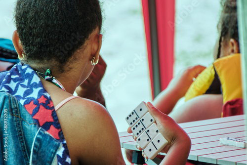 Girl playing dominoes with friends at the beach park