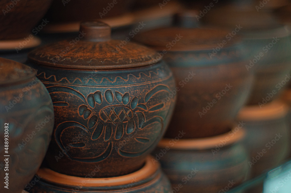 A row of handmade clay pots, selective focus A row of handmade clay pots, selective focus