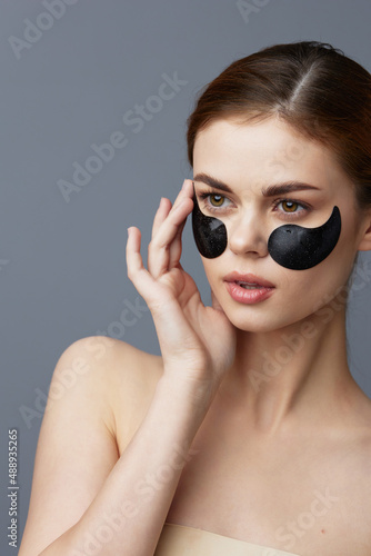 portrait woman skin care anti wrinkle eye patches Gray background