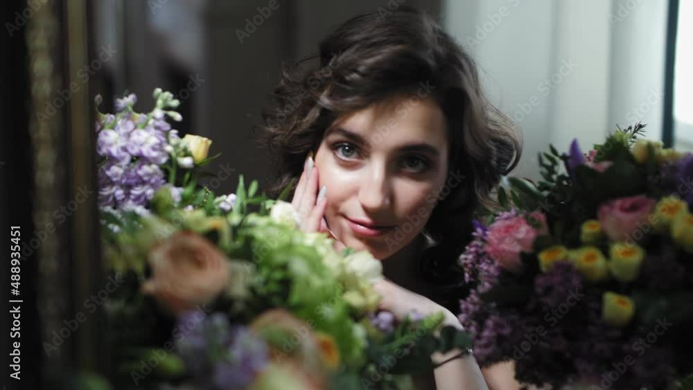 The girl looks into the camera through the mirror. Abundant number of bouquets The girl looks into the camera through the mirror. Abundant number of bouquets