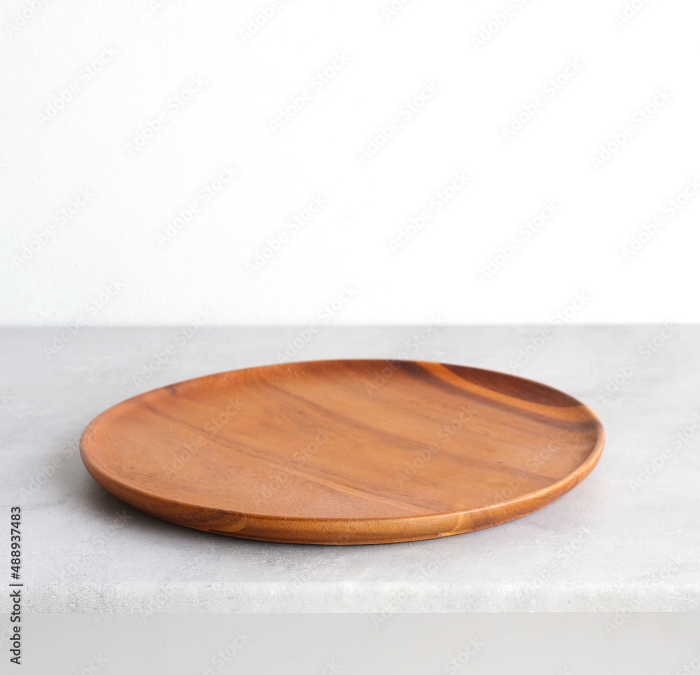 Empty round wooden plate on gray cement table background, banner with copy space, Blank wood tray for food display montage, template, mock up, top view, flat lay Empty round wooden plate on gray cement table background, banner with copy space, Blank wood tray for food display montage, template, mock up, top view, flat lay
