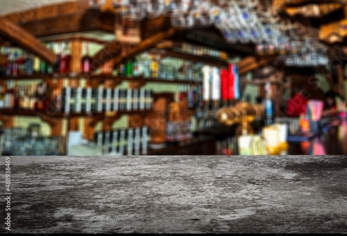 Grey table top and beautiful bokeh shelves with alcohol bottles on the background. Bar concept. © BillionPhotos.com
