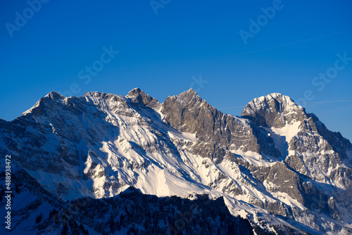 Aerial view of mountain panorama at the Swiss Alps seen from ski resort Engelberg  focus on background. Photo taken February 9th  2022  Engelberg  Switzerland.