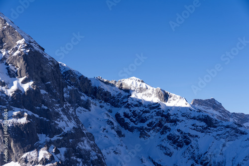 Aerial view of mountain panorama at the Swiss Alps seen from ski resort Engelberg  focus on background. Photo taken February 9th  2022  Engelberg  Switzerland.