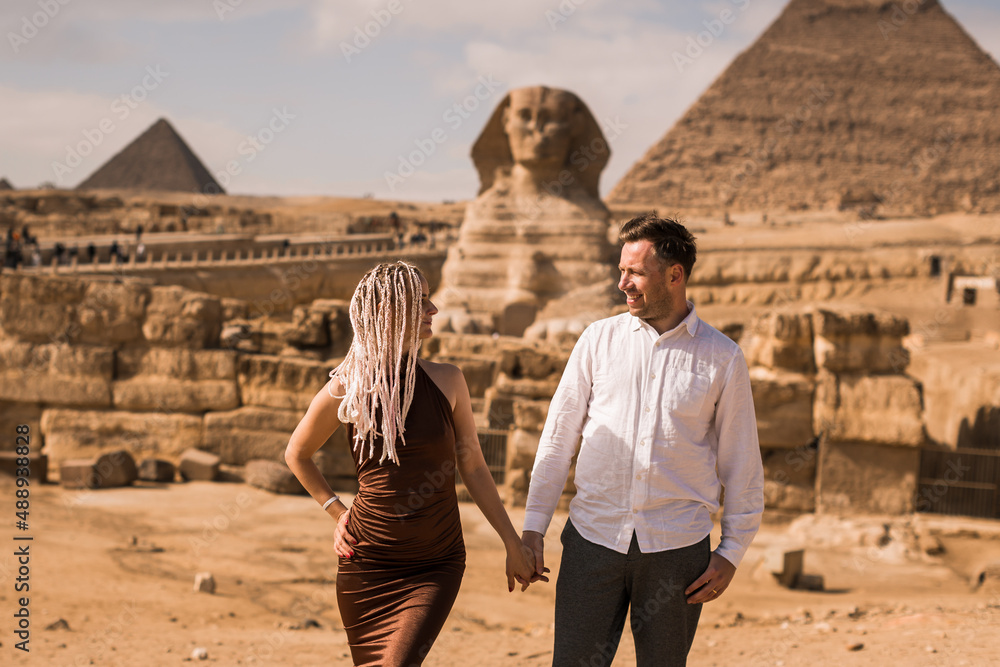 Happy couple and Pyramid, Cairo, Egypt. Tourists having fun in Giza - obrazy, fototapety, plakaty 