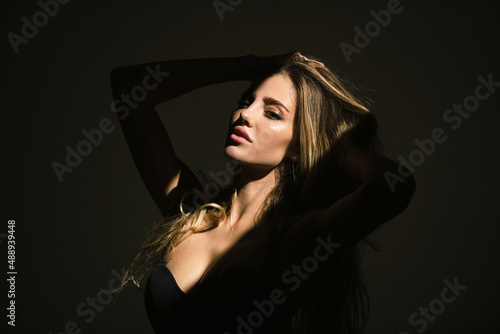 Foto Elegant young woman posing over black background