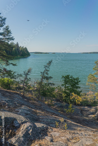 Seascape, view of the sea, rocks and northern low pine trees on a sunny day. Finnish nature. Turku. Vacation, vacation, relaxation concept