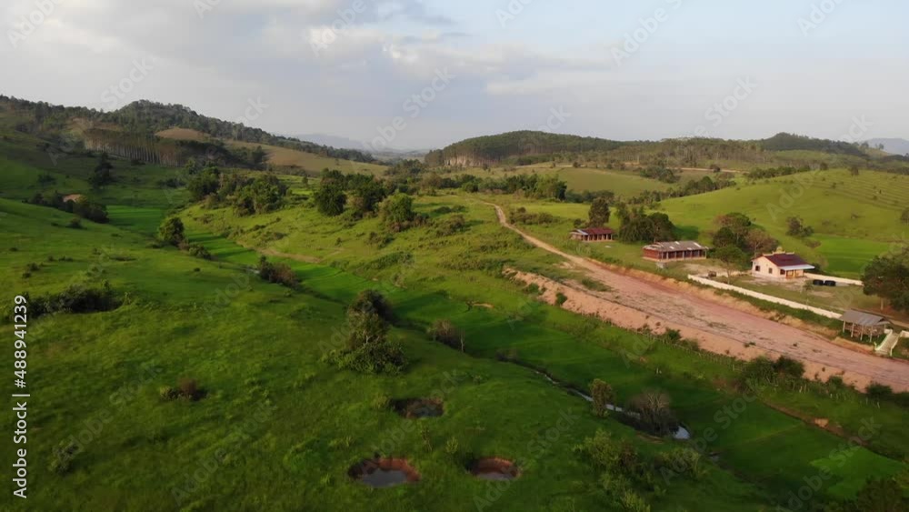 Drone dolly in over a few buildings and dirt road at Muang Souy, Laos. Beautiful rolling hills and green vegetation surrounding. Drone dolly in over a few buildings and dirt road at Muang Souy, Laos. Beautiful rolling hills and green vegetation surrounding.