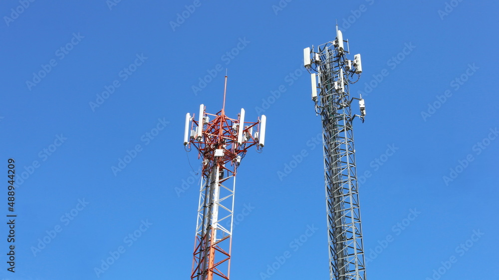 4G and 5G Cellular Base Station. Twin Base Transceiver Station (BSC) radio transceiver device with cellular telephone cellular wireless communication on metal towers on cloudy sky background with copy 4G and 5G Cellular Base Station. Twin Base Transceiver Station (BSC) radio transceiver device with cellular telephone cellular wireless communication on metal towers on cloudy sky background with copy