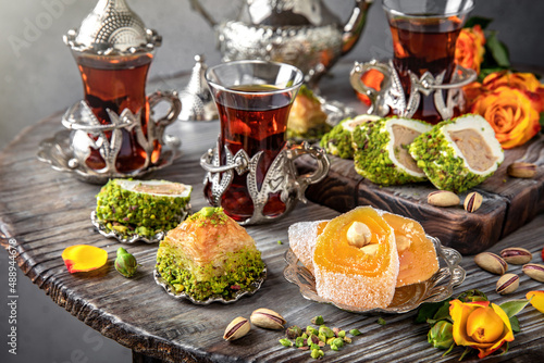 Oriental sweets. Lukum, pistachio baklava. Fragrant tea. Turkish mood still life. For advertising, window dressing, travel posters and cafes.