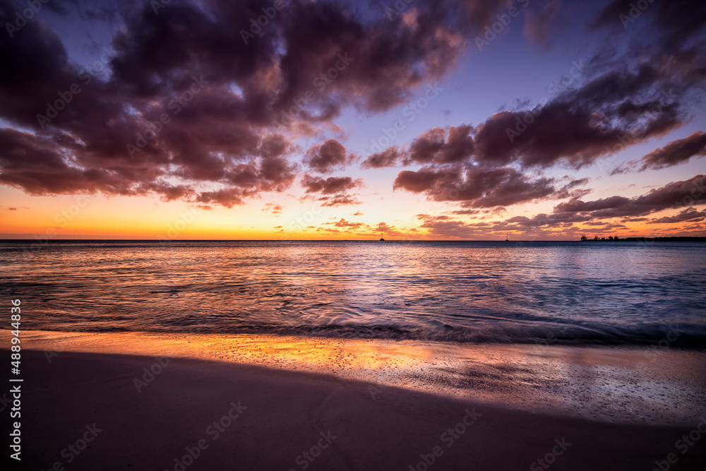 A beautiful sunset sky at a tropical beach with waves in the Caribbean sea as a background A beautiful sunset sky at a tropical beach with waves in the Caribbean sea as a background