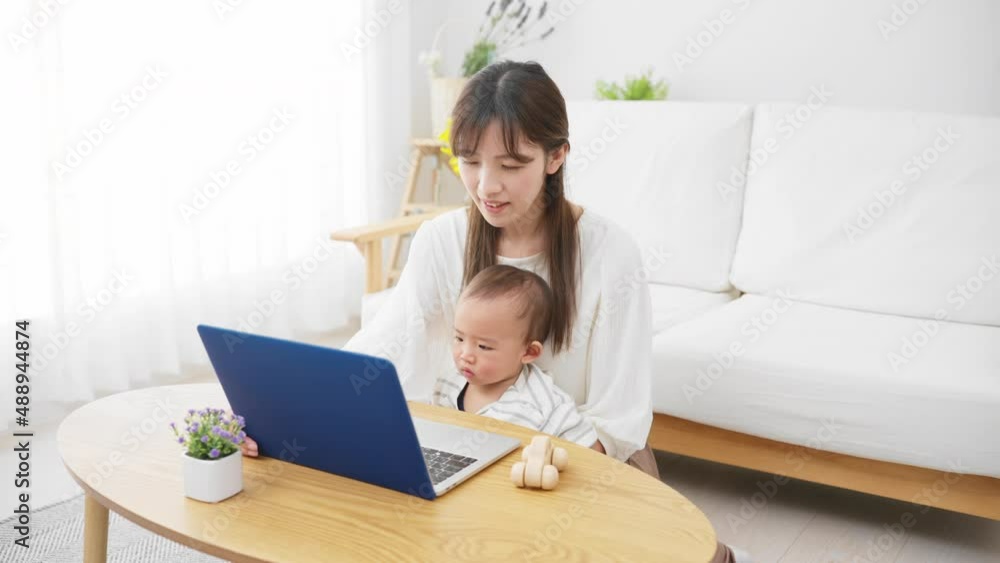 ノートパソコンを赤ちゃんに見せる母親 ノートパソコンを赤ちゃんに見せる母親